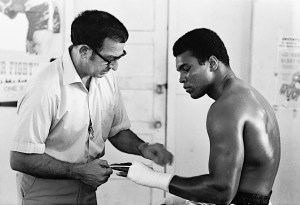 Muhammad Ali getting his hands wrapped by trainer Angelo Dundee before training session at the 5th Street Gym. Miami Beach, Florida 10/9/1970 (Image # 2045 )