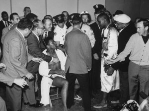 Sonny Liston (3R), at weighting-in ceremonies before world championship fight with Cassius Clay (L, sitting).